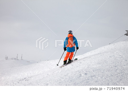 Skier before downhill on freeride slope and overcast misty sky Skier before downhill on freeride slope and overcast misty sky 71940974