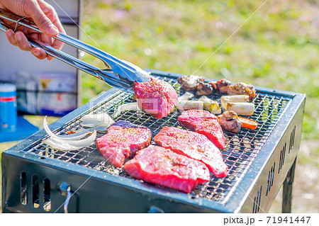 屋外のオープングリルで牛肉を網焼きしている様子 71941447