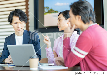 怒る女 カフェで年上の先輩に意見を言う若い女性の写真素材