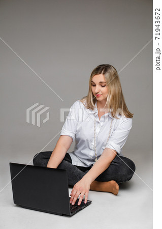 Woman using laptop with legs crossed. Isolate on 71943672