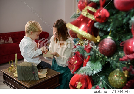 Boy with Cochlear Implants Seal Letter To Santa Claus For New Year 71944045
