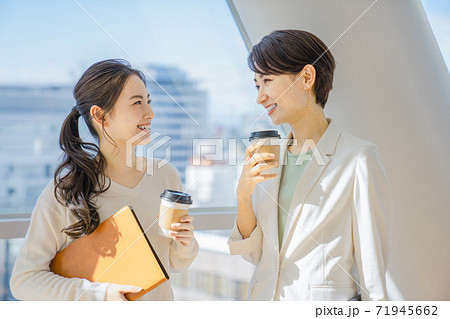 オフィスでコーヒー片手に談笑するビジネスウーマン 71945662
