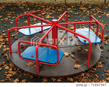 Round swing in the playground covered with yellow leaves Round swing in the playground covered with yellow leaves 71947567
