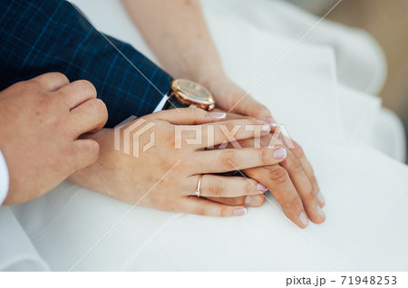 close-up portrait of the bride and groom. They hug their arms. Wedding rings on their hands close-up portrait of the bride and groom. They hug their arms. Wedding rings on their hands 71948253