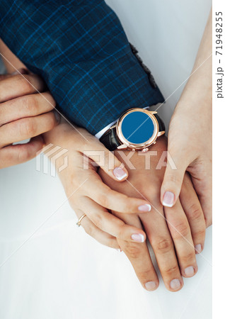 close-up portrait of the bride and groom. They hug their arms. Wedding rings on their hands close-up portrait of the bride and groom. They hug their arms. Wedding rings on their hands 71948255