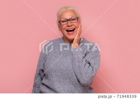 Surprised elderly lady with hands on face see the unbelievable. Surprised elderly lady with hands on face see the unbelievable. 71948339