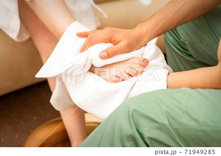 Masseur wiping the woman's legs Masseur wiping the woman's legs 71949285