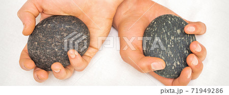 Masseur holding hot massage stones Masseur holding hot massage stones 71949286