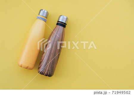 Reusable eco friendly metal water bottles on yellow background. Reusable eco friendly metal water bottles on yellow background. 71949502