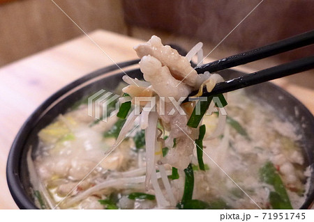 【GOTOEAT　居酒屋】もつ鍋の食材を持ち上げる 71951745