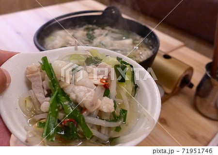 【GOTOEAT　居酒屋】もつ鍋の食材を持ち上げる 71951746