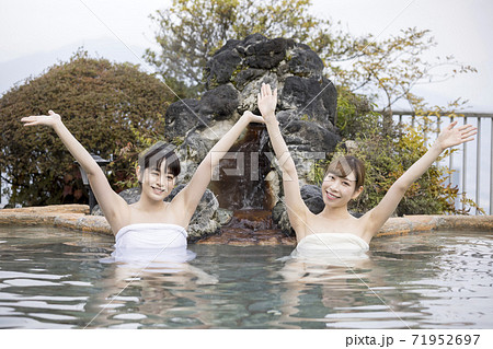 露天風呂で万歳をする若い女性2人組 71952697