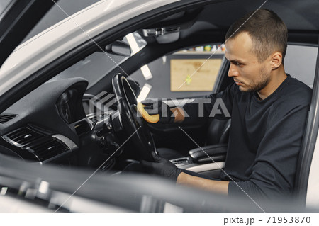 Man polish salon of car in a garage 71953870