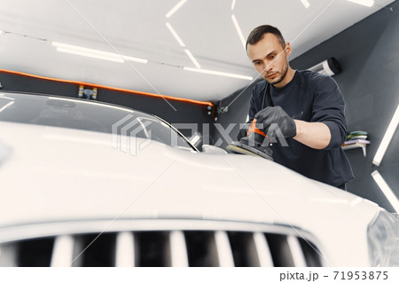 Man polish a car in a garage Man polish a car in a garage 71953875