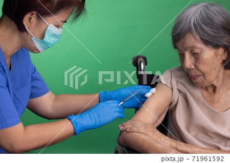 Chroma key, nurse doing vaccine injection to senior woman. Chroma key, nurse doing vaccine injection to senior woman. 71961592