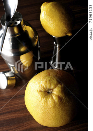 グレープフルーツやレモンを使ってシェーカーでカクテルを作る 71963153