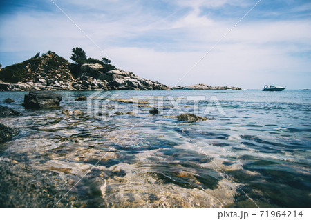 Seascape with views of a rocky boulder taken at the level of the sea surface Seascape with views of a rocky boulder taken at the level of the sea surface 71964214