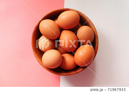 Top view of eggs in a bowl on color background  71967933