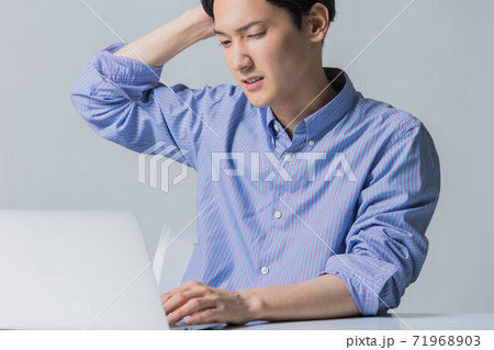 仕事で失敗をしてしかめっ面の若い男性 仕事で失敗をしてしかめっ面の若い男性 71968903