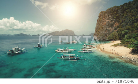 Passenger ship at sea coast with green cliff shore. Sun tropical seascape with tourists rest Passenger ship at sea coast with green cliff shore. Sun tropical seascape with tourists rest 71971046