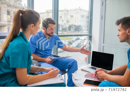 Medical workers discussing working issues and looking involved 71972782