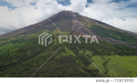 Closeup Philippines volcano top erupt clouds of haze aerial. Green grass mountain with hiking path Closeup Philippines volcano top erupt clouds of haze aerial. Green grass mountain with hiking path 71973050
