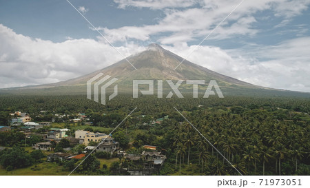Tropic countryside with palm trees aerial. Mayon volcano hillside valley. Rural cityscape cottages Tropic countryside with palm trees aerial. Mayon volcano hillside valley. Rural cityscape cottages 71973051