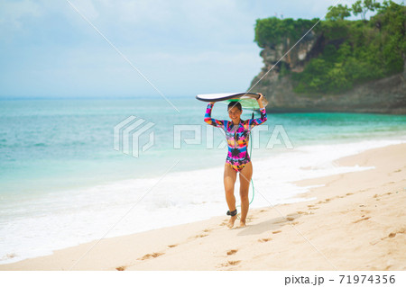 Sexy slim girl with surf board on tropical sand beach. Healthy active lifestyle in summer vocation. 71974356