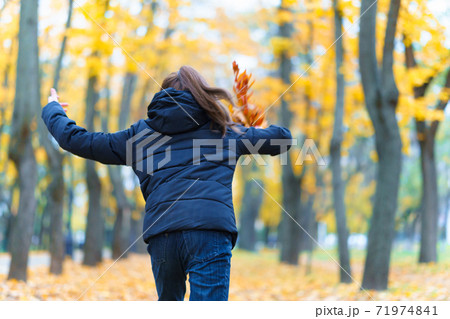 a girl running through the park and enjoys autumn, beautiful nature with yellow leaves a girl running through the park and enjoys autumn, beautiful nature with yellow leaves 71974841