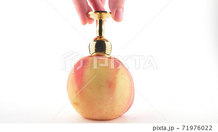 close-up. ripe peach with jewelry anal plug inside. White background. copy space 71976022
