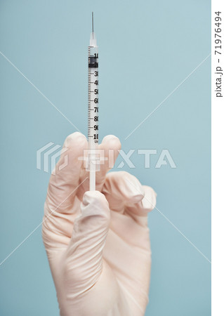 Doctor holding a syringe for injection in studio 71976494