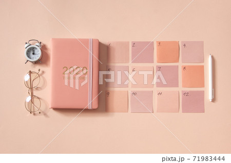 Flat lay of notepad with words Goals 2021, colorful sticky notes, o'clock, pen and pen case. Coral pink background 71983444