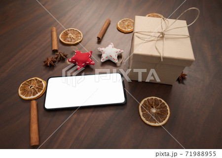 smarthone with white screen and christmas decorations on walnut table 71988955