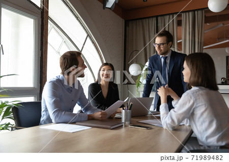 Interested male boss listening to ideas expressed by staff members Interested male boss listening to ideas expressed by staff members 71989482