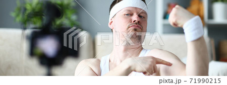 Expressive young man demonstrating his strong muscles 71990215