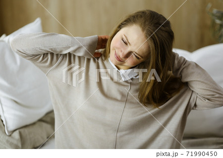 Tired woman massaging rubbing stiff sore neck tensed muscles fatigue from computer work in incorrect posture. Stay at home concept during Coronavirus pandemic and self isolation quarantine Tired woman massaging rubbing stiff sore neck tensed muscles fatigue from computer work in incorrect posture. Stay at home concept during Coronavirus pandemic and self isolation quarantine 71990450