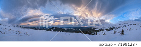 Picturesque winter windy and cloudy morning alps. Ukrainian Carpathians highest ridge is Chornohora with peaks of Hoverla and Petros mountains. View from Svydovets ridge  Dragobrat ski resort. 71991237