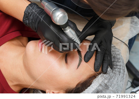 The master applies eyebrow makeup paint to the 71991324
