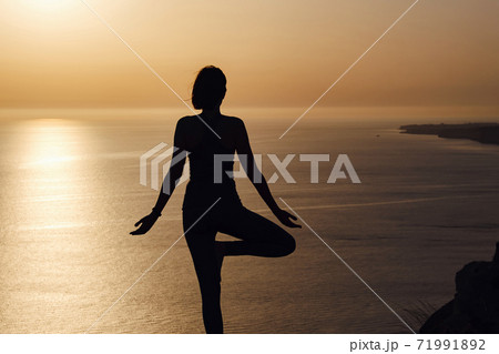 The woman with yoga posture on the mountain at sunset 71991892