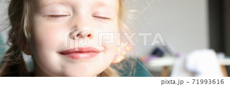 Little girl with closed eyes smiles and holds pens together. Little girl with closed eyes smiles and holds pens together. 71993616