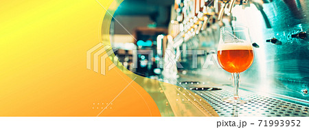 Glass with foaming lager on bar rack. Horizontal banner, flyer for ad. Glass with foaming lager on bar rack. Horizontal banner, flyer for ad. 71993952