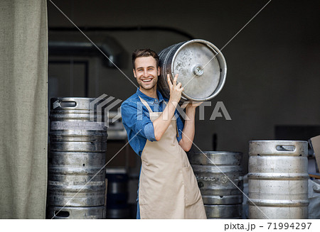 Modern brewery and worker with keg on plant, small business and beer industry Modern brewery and worker with keg on plant, small business and beer industry 71994297