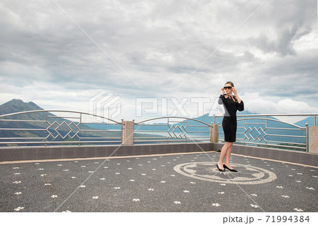 Nice woman wearing in black dress against the backdrop of the volcanoes Batur and Agung 71994384
