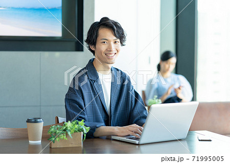 コワーキングスペースでパソコン作業をする若い男性 コワーキングスペースでパソコン作業をする若い男性 71995005