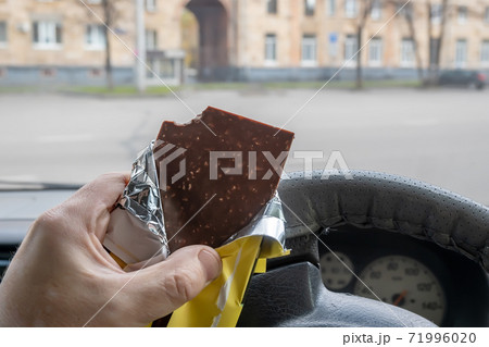 chocolate bar with nuts in the driver hand chocolate bar with nuts in the driver hand 71996020