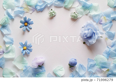 白背景に造花の青い花と花びらで囲んだフレーム 平置きの俯瞰撮影 の写真素材
