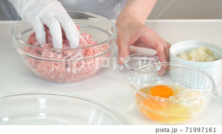 挽き肉に塩胡椒を混ぜてこねる主婦 料理シーン 挽き肉に塩胡椒を混ぜてこねる主婦 料理シーン 71997161