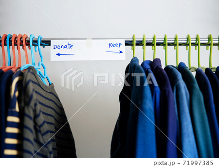 Donation Concept. Separated Used Old Clothes from Wardrobe Rack to Keep and Donate. Focus on Text Donation Concept. Separated Used Old Clothes from Wardrobe Rack to Keep and Donate. Focus on Text 71997385