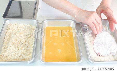 豚肉にパン粉を塗している調理シーン 豚肉にパン粉を塗している調理シーン 71997405