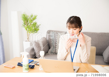 仕事中にマスクを付ける女性 71998006